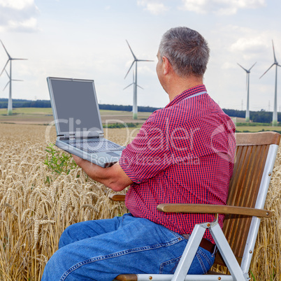 Man with laptop in cornfield