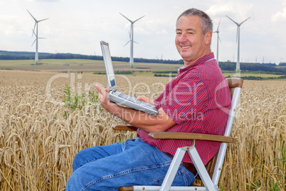 Man with laptop in cornfield