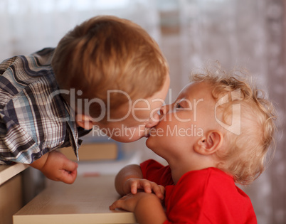cute siblings. two little brothers are kissing.