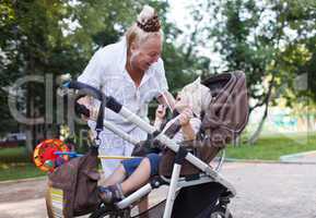 granny playing with her grandson in pram