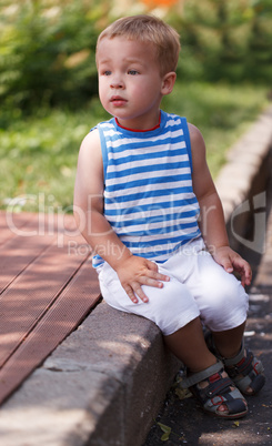 cute boy sitting on the curb