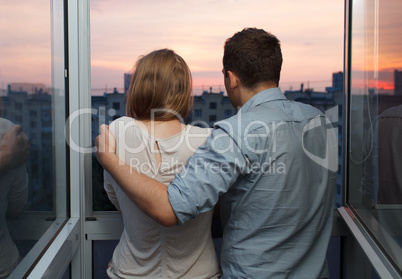 young couple on the balcony watching sunset