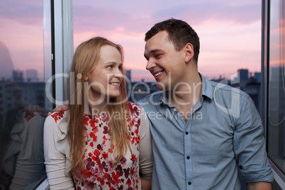 young couple on the balcony looking to each other