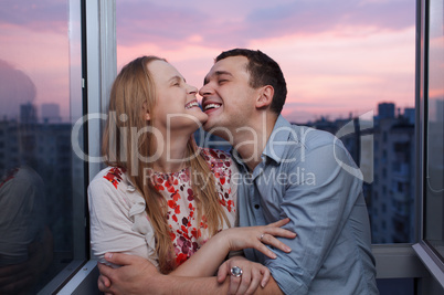 young couple on the balcony embracing and laughing