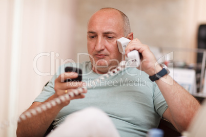 businessman in the office speaking on two phones