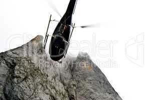 Helikopter vor gewaltiger Felswand mit gelben Streifen