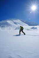 Skitourengeher mit Sonnenstern auf Gletscher