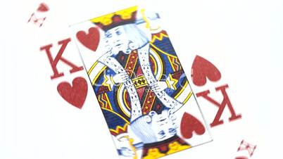 Red king playing card rotates on white background