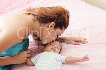 Young mother kissing her small newborn