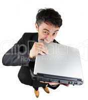 Frustrated businessman biting his laptop