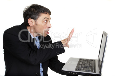 Businessman casting a spell on his laptop