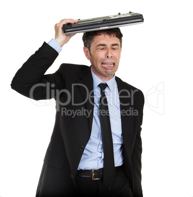 Crying man sheltering under his laptop