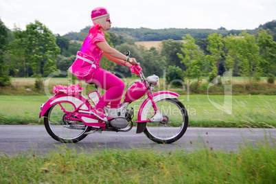 Woman rides on pink scooter