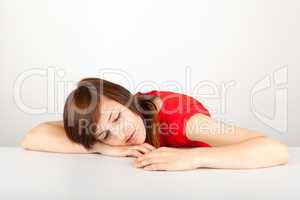 Die junge Frau liegt schlafend auf einem Tisch