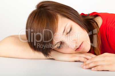 Die junge Frau liegt schlafend auf einem Tisch