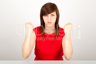 Die junge Frau sitzt wütend an einem Tisch