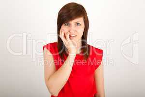 Die junge Frau hat Zahnschmerzen und hält sich die Wange