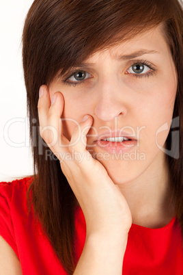 Die junge Frau hat Zahnschmerzen und hält sich die Wange