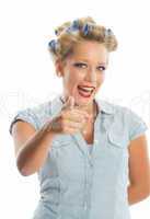 Blonde Frau mit Lockenwicklern zeigt mit dem Finger