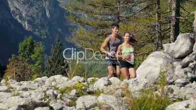 1of4 Young man and woman running on mountain trail, sport