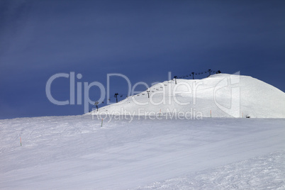 ski slope and ropeway against blue sky