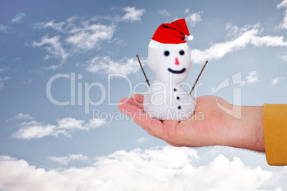Hand holding snowman with Santa Claus hat