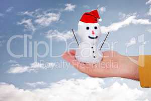 Hand holding snowman with Santa Claus hat
