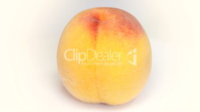 Ripe  peach fruit rotating on white background