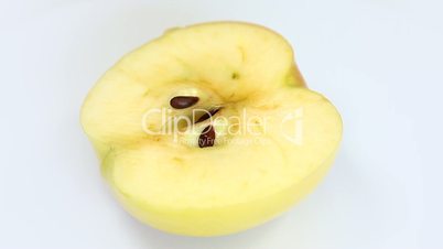 Sliced fresh yellow apple rotating on white