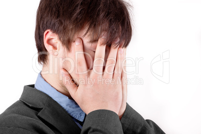 Young man holding his hands over his face