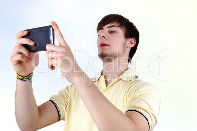 Young Man with serious look on his smartphone looks