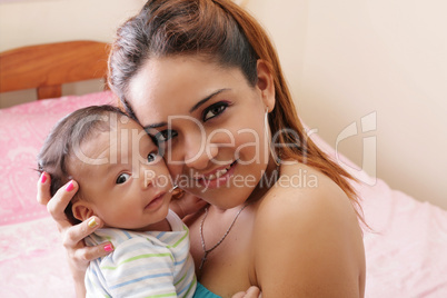 Portrait of a beautiful hispanic happy mother with smiling baby