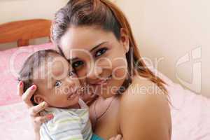 Portrait of a beautiful hispanic happy mother with smiling baby