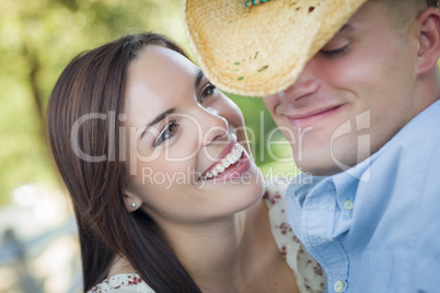 Mixed Race Romantic Couple with Cowboy Hat Flirting in Park