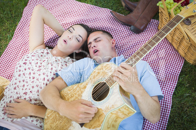 Mixed Race Couple at the Park Playing Guitar and Singing