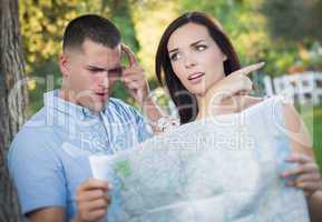 Lost and Confused Mixed Race Couple Looking Over Map Outside