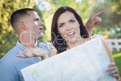 Lost and Confused Mixed Race Couple Looking Over Map Outside