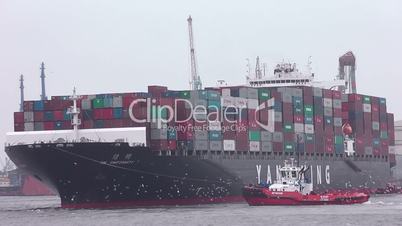 Hafenschlepper mit Containerschiff