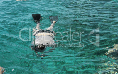 woman photographer diving into water of red sea