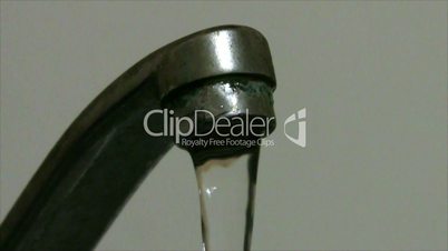water falls from old faucet close-up