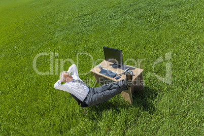 Businessman Relaxing Thinking At Desk in Green Field