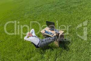 Businessman Relaxing Thinking At Desk in Green Field