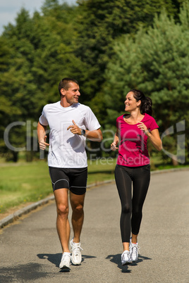 Caucasian couple running in park