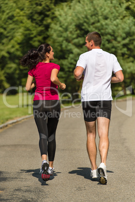 Rear view of couple friends jogging together