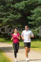 Young smiling couple running in park