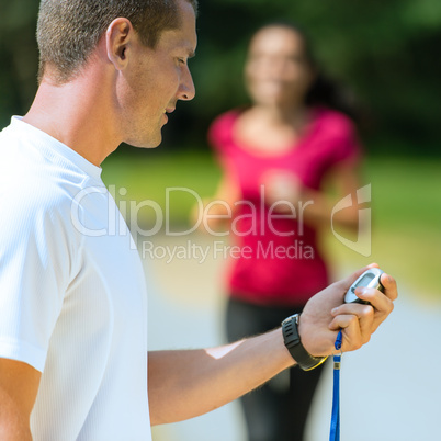 Portrait of male coach timing runner