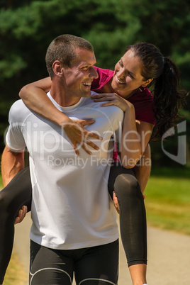 Smiling man giving piggyback ride his girlfriend