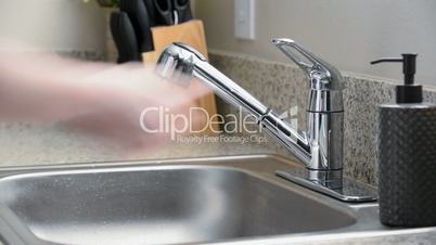 Man leaves kitchen sink faucet running after washing hands