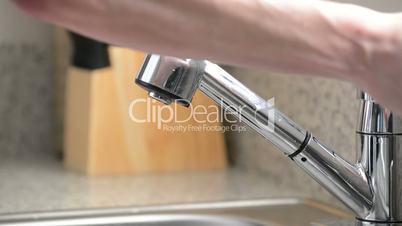 Close up of man washing hands in kitchen sink