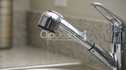 Close up dripping kitchen sink faucet, slow motion, overcranked